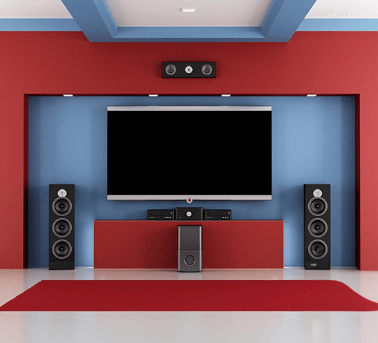 A red and blue room with speakers, a tv and a large screen.